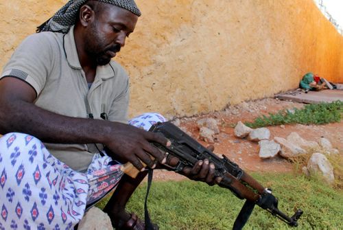 A Somali clansman cleans his AK-47 assault rifle.