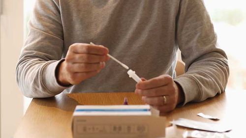 A man uses a COVID-19 rapid antigen test kit in Sydney.