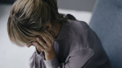 Sad woman with head in her hands