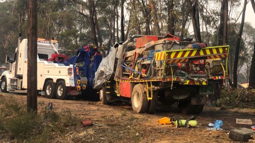 The firefighters' truck rolled after it was struck by a falling tree.