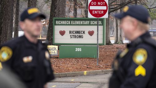 FILE - Police look on as students return to Richneck Elementary on Jan. 30, 2023, in Newport News, Va. A grand jury in Virginia has indicted the mother of a 6-year-old boy who shot his teacher on charges of child neglect and failing to secure her handgun in the family's home, a prosecutor said Monday, April 10. (Billy Schuerman/The Virginian-Pilot via AP, File)