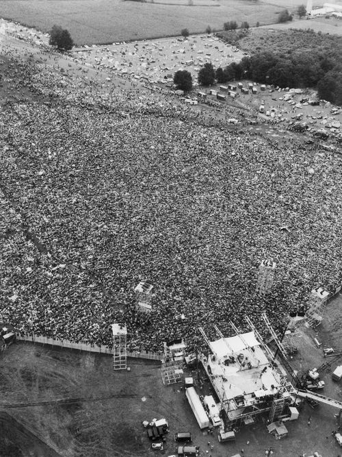 In this August 16, 1969 file aerial photo, music fans at the original Woodstock Music and Arts Festival are packed around the stage, at bottom, in Bethel, N.Y. Archaeologists from New York's Binghamton University are trying to find the exact location of the stage and light and speaker towers and say aerial shots taken nearly 50 years ago can't be relied upon to help them, because the bottom of the hillside was re-graded in the late '90s to accommodate a temporary stage for anniversary performances, and the spot of the original stage is under a layer of compacted fill. (AP Photo/Marty Lederhandler, File) 