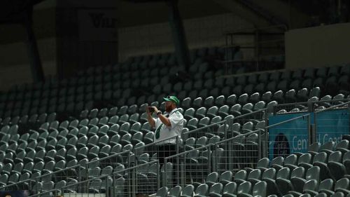 A security guard stands in an empty stadium in Gosford during an A-League game last month.