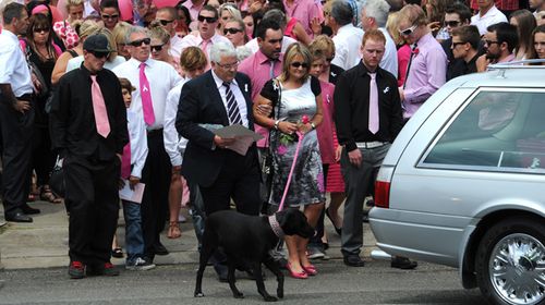 Mother Noelle Dickson leaves the church with Sarah Cafferkey's dog Sprocket on a pink leash.