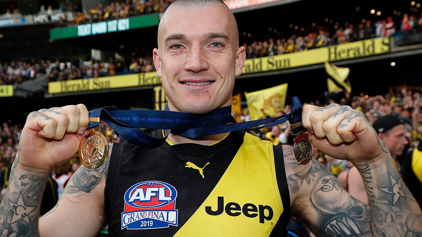 Dustin Martin of the Tigers poses for a photograph with the Norm Smith Medal and his Premiership Medal 