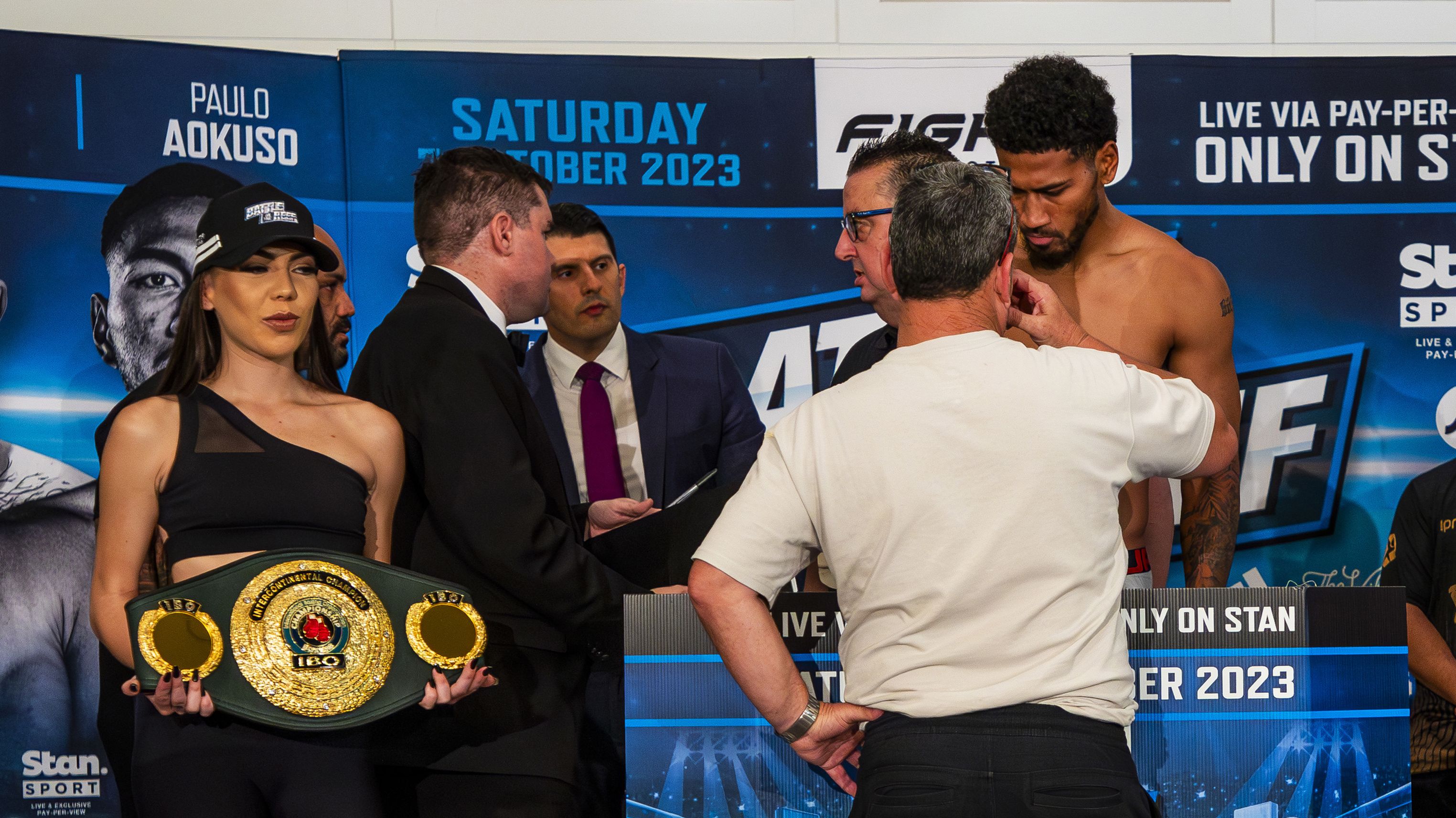 Officials confer while Paulo Aokuso is weighed a day out from the IBO title fight.