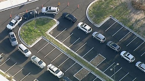 Cars snake around the car park as people wait to be tested in Keysborough in Victoria.