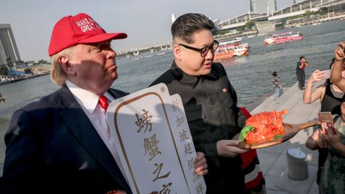 They posed with mock chili and black pepper crab dishes and took photographs with curious passers-by. Picture: EPA