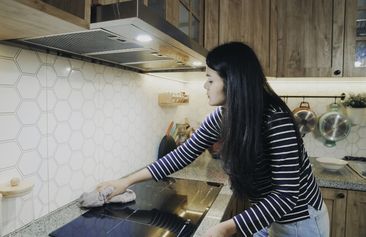 asian Chinese woman indoors at home, cleaning kitchen