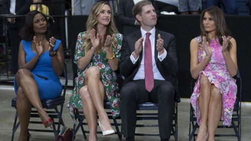 Omarosa Manigault, Eric Trump, the son of President Donald Trump and his wife Lara Trump and first lady Melania Trump sit to the side of the stage as President Donald Trump speaks during a Make America Great Again rally. (AAP)