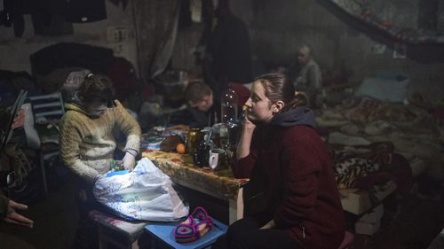 Anna sits with her daughter Nastya, left, in a basement as Russian attacks continues nearby, in Soledar, Donetsk region, Ukraine.