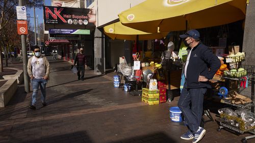 Shopkeeper Elias waits for customers in Fairfield, Sydney.