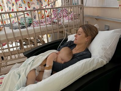 Mia Rose Steffe snuggles up to mum Carlie in hospital during cancer treatment.