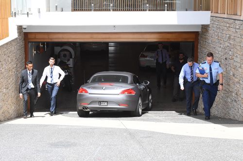 Salim Mehajer reverses his BMW Z4 out of the underground carpark as police raid his home today. (AAP)