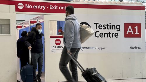 FILE - Passengers get a COVID-19 test at Heathrow Airport in London, Nov. 29, 2021.  The Biden administration is lifting its requirement that international air travellers to the U.S. take a COVID-19 test within a day before boarding their flights, easing one of the last remaining government mandates meant to contain the spread of the coronavirus.