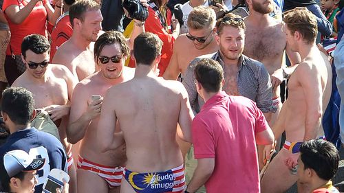 Jack Walker, second from right, unbuttoning his shirt surrounded by mates at the Malaysian Grand Prix. (AFP)