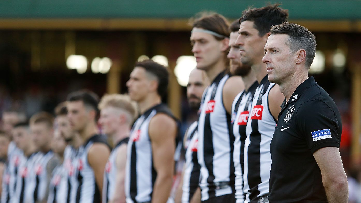 Collingwood coach Craig McRae stands with his team for the national anthem