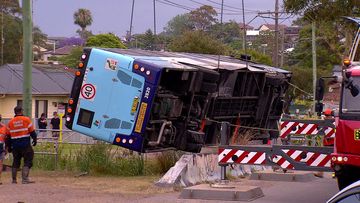 The vehicle ploughed into a concrete barrier and two men on board were flung from the bus after the accident in Lake Macquarie, NSW.