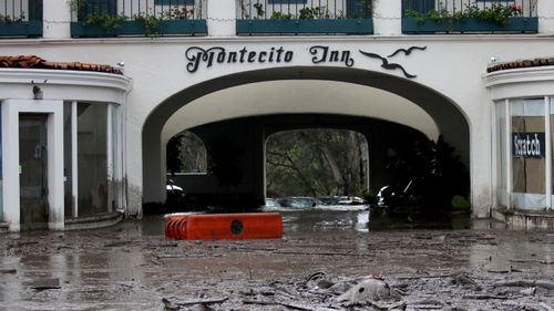 Debris and mud cover the entrance of the Montecito Inn. (Image: AAP)