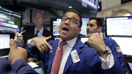 Specialist Paul Cosentino, centre, works at his post on the floor of the New York Stock Exchange.