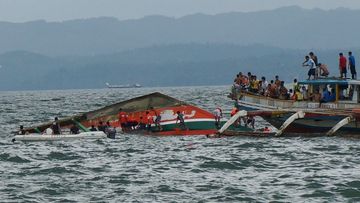 Rescuers help passengers from a capsized ferry boat in Ormoc city. (AAP)