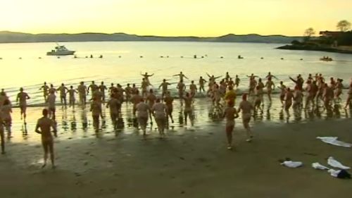 Hundreds get naked for early morning dip in Hobart's Derwent River