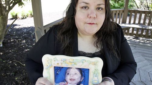  Alyssa Pladl, holds a photo of her daughter, Katie, when she was an infant. (AAP)