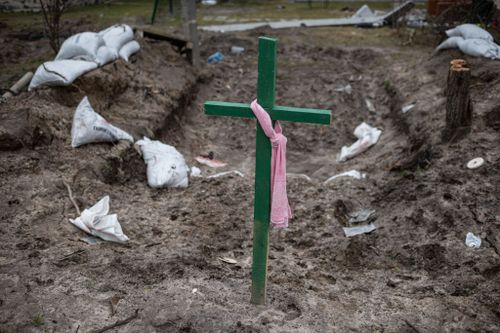  A green cross stands above an abandoned military vehicle position where locals buried four people, on April 5, 2022 in Bucha, Ukraine. The Ukrainian government has accused Russian forces of committing a "deliberate massacre" as they occupied and eventually retreated from Bucha, 25km northwest of Kyiv. Dozens of bodies have been found in the days since Ukrainian forces regained control of the town. (Photo by Alexey Furman/Getty Images)