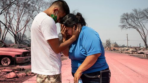 Dora Negrete (Right) is consoled consoled by her son, Hector Rocha (Left) , after seeing their destroyed mobile home in Talent, Oregon.