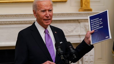 President Joe Biden holds a booklet as he speaks about the coronavirus in the State Dinning Room of the White House, Thursday, Jan. 21, 2021, in Washington. (AP Photo/Alex Brandon)