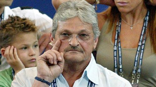 Nick Philippoussis watches son Mark Philippoussis play against Dominik Hrbaty of the Slovak Republic in a men's singles match in the Hopman Cup at the Burswood Dome in Perth on January 2005. (AFP)