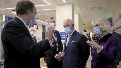 Britain's Prince Charles and Camilla, Duchess of Cornwall talk with Health Secretary Matt Hancock, left, and staff during a visit to the Queen Elizabeth Hospital in Birmingham, England, Wednesday Feb. 17, 2021, to thank volunteers undertaking clinical trials for the COVID-19 vaccinations.