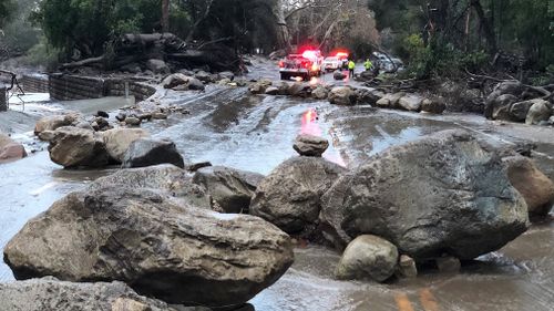 Santa Barbara County Firefighters work admist flood waters and debris flow during heavy rains in Montecito. (AAP)