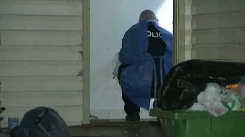 An officer examines a doorway to the home. (9NEWS)