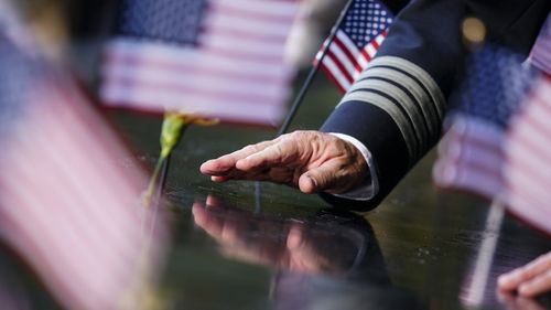 A person touches an inscribed name at the National September 11 Memorial and Museum ahead of the 20th anniversary of the 9/11 terrorist attacks in New York City.