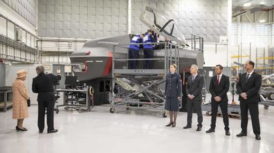 The Queen watches air crew at work on a training model F-35B Lightning II fighter.