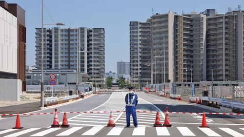 A security man stands on guard at the entrance to the Tokyo 2020 Olympic Village in Harumi