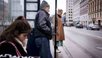 Passengers at a bus stop in Copenhagen, Denmark, Tuesday, February 1, 2022. 