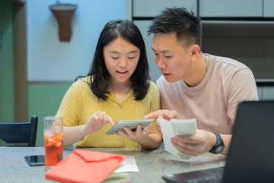 Asian couple at home discuss about financial expenses