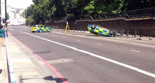 A police car flipped in a pursuit near Buckingham Palace yesterday. Image: AAP