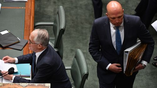 Peter Dutton walks behind Malcolm Turnbull at Question Time yesterday.