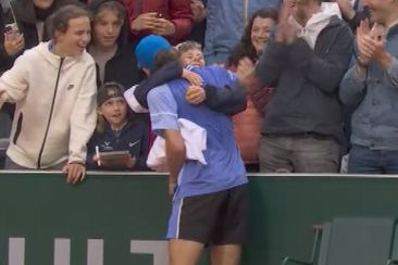 Alex De Minaur hugs a young fan after securing a spot in the fourth round at Roland-Garros with a win over Jan-Lennard Struff.
