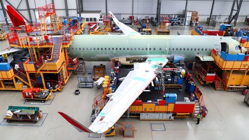 Airbus employees work on a factor final assembly line