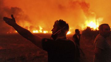 People react as they try to extinguish a wildfire in Avantas village, near Alexandroupolis town, in the northeastern Evros region, Greece, Monday, Aug. 21, 2023. 