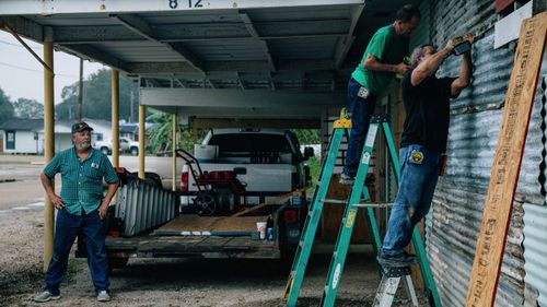 Workers board up a workshop ahead of Hurricane Delta in Abbeville, Louisiana, on October 8, 2020. 