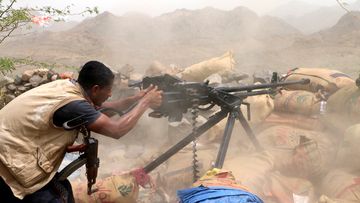  A member of Yemeni government forces fires a heavy machine gun during an offensive against Houthi positions on the outskirts of the western port city of Hodeidah, Yemen. (AAP)