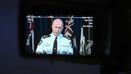 Acting AFP Commissioner Neil Gaughan is seen through a view finder as he speaks to the media.