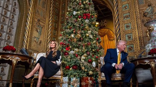 O presidente Donald Trump fala acompanhado pela primeira-dama Melania Trump, durante uma chamada do NORAD, Comando de Defesa Aeroespacial da América do Norte, que rastreia a Operação Santa em seu clube Mar-a-Lago.