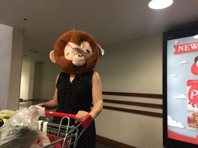 Mum grocery shopping wearing gorilla head