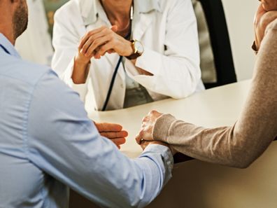 Couple sitting in office with doctor